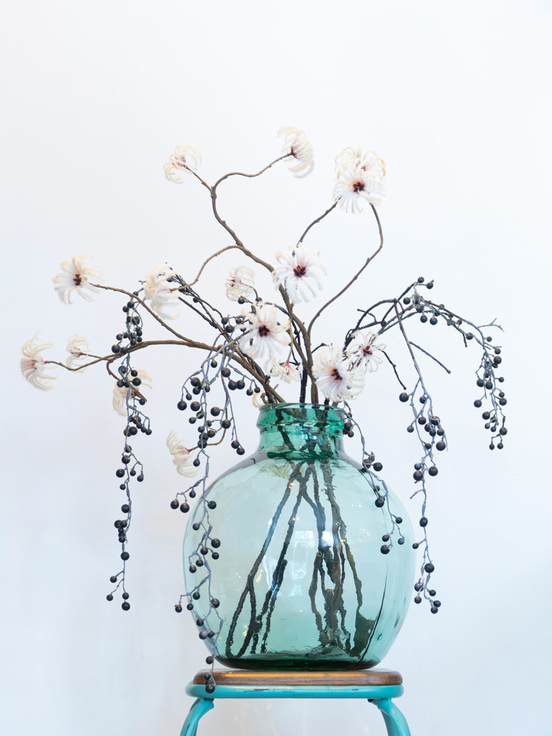 teal glass vase with flowers