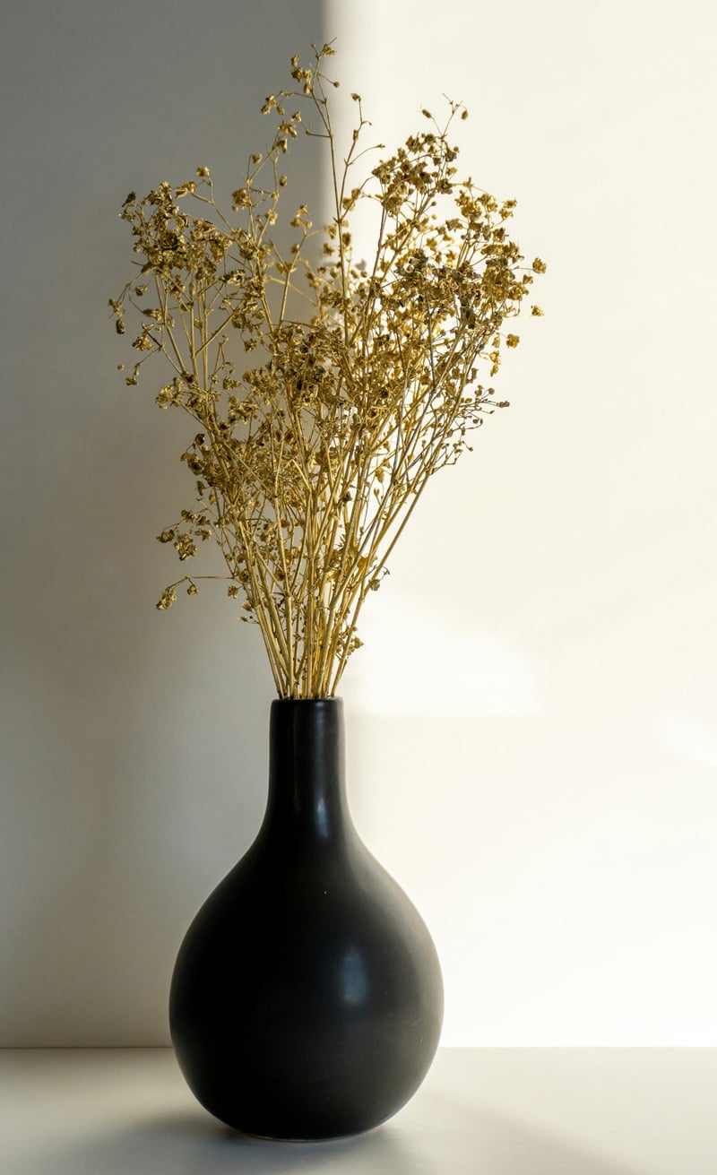 black vase with golden flowers
